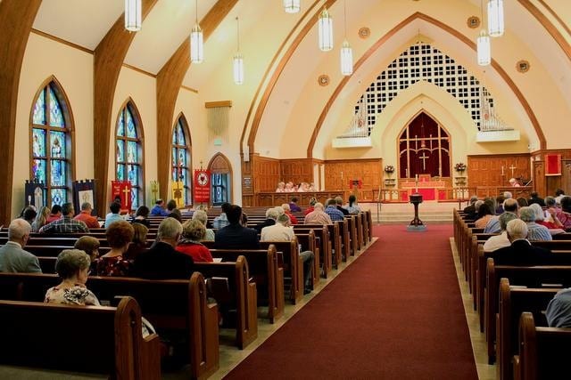 Interior of a traditional Christian church with stained glass windows and warm light